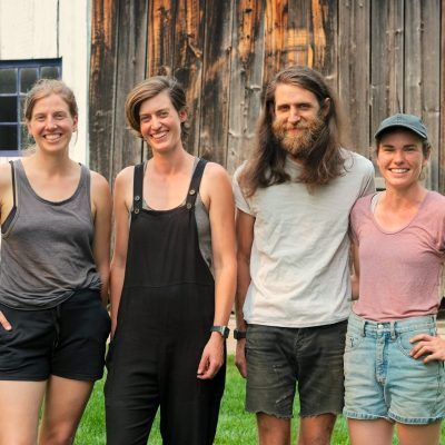 four young farmers stand together smiling