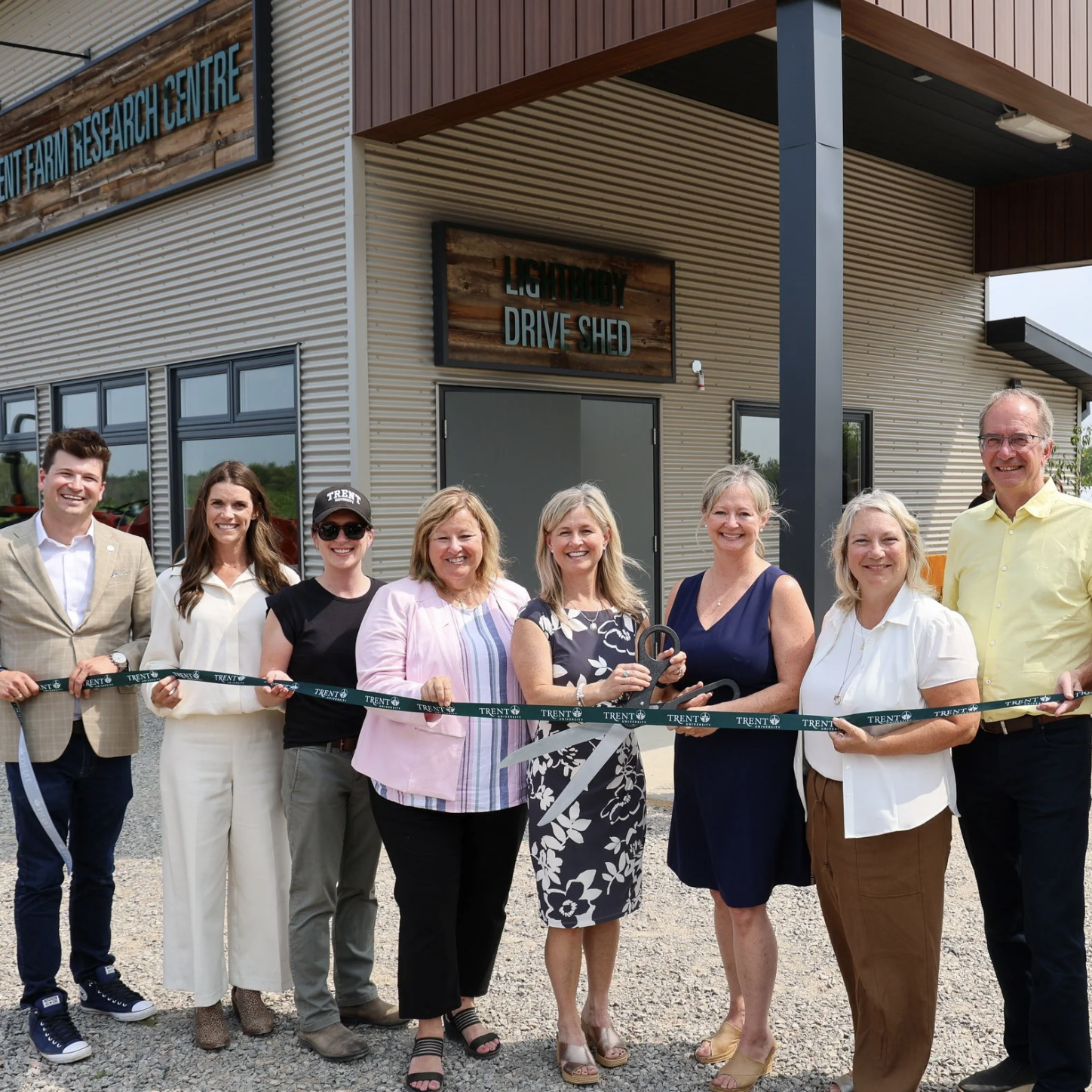Photo of researchers smiling and standing outside of the Trent Farm Research Centre