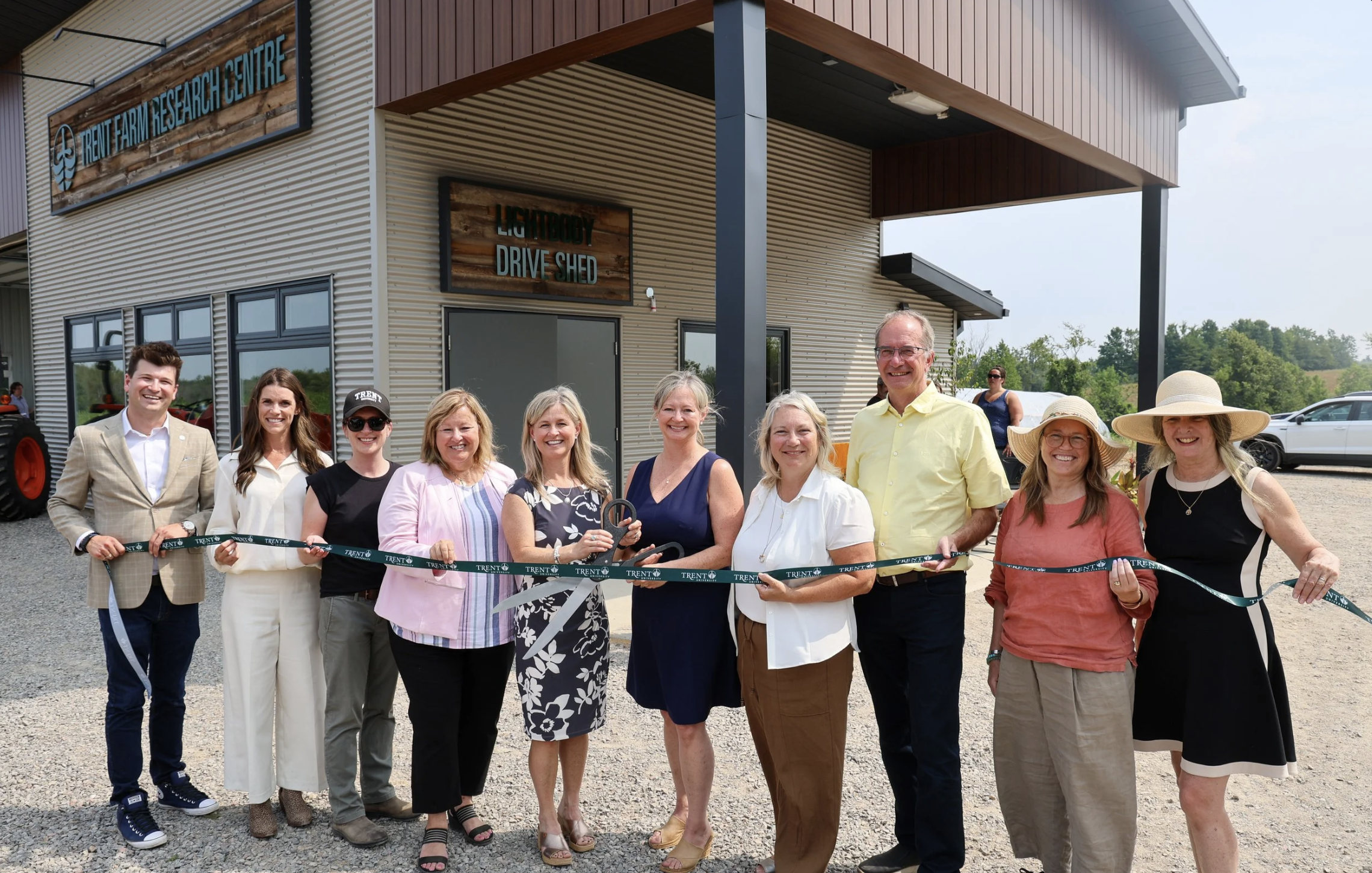 Photo of researchers smiling and standing outside of the Trent Farm Research Centre