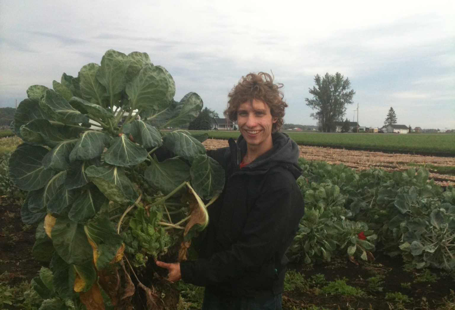 Photo of Travis Cranmer in a field of crops