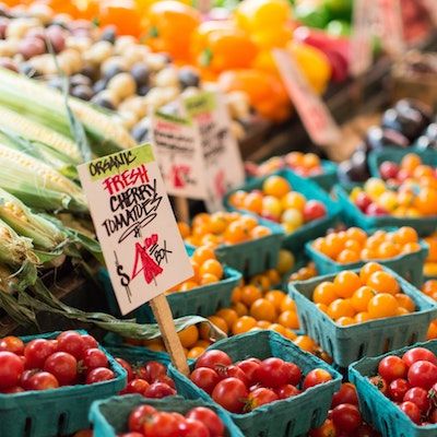 Red and orange cherry tomatoes for sale at a farmers market