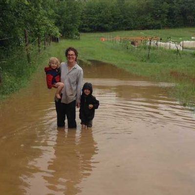 farmer and kids standing in flood water on farm
