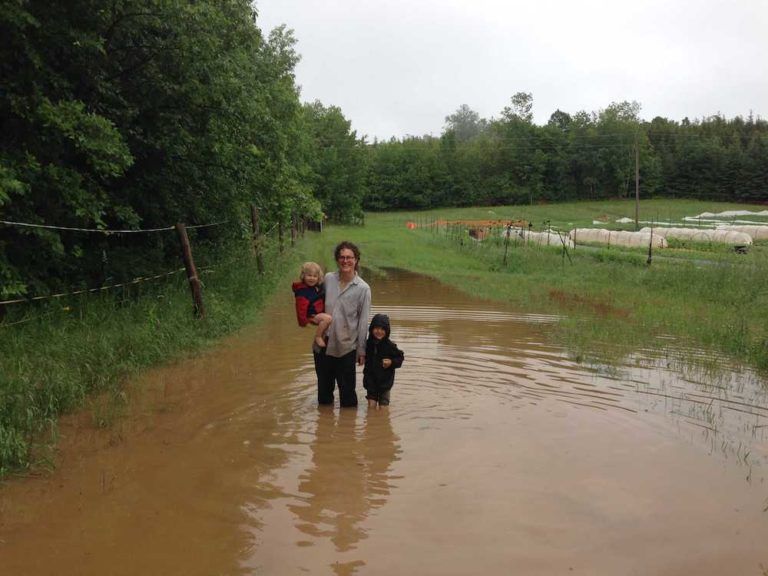 farmer and two kids standing in huge flood water on farm